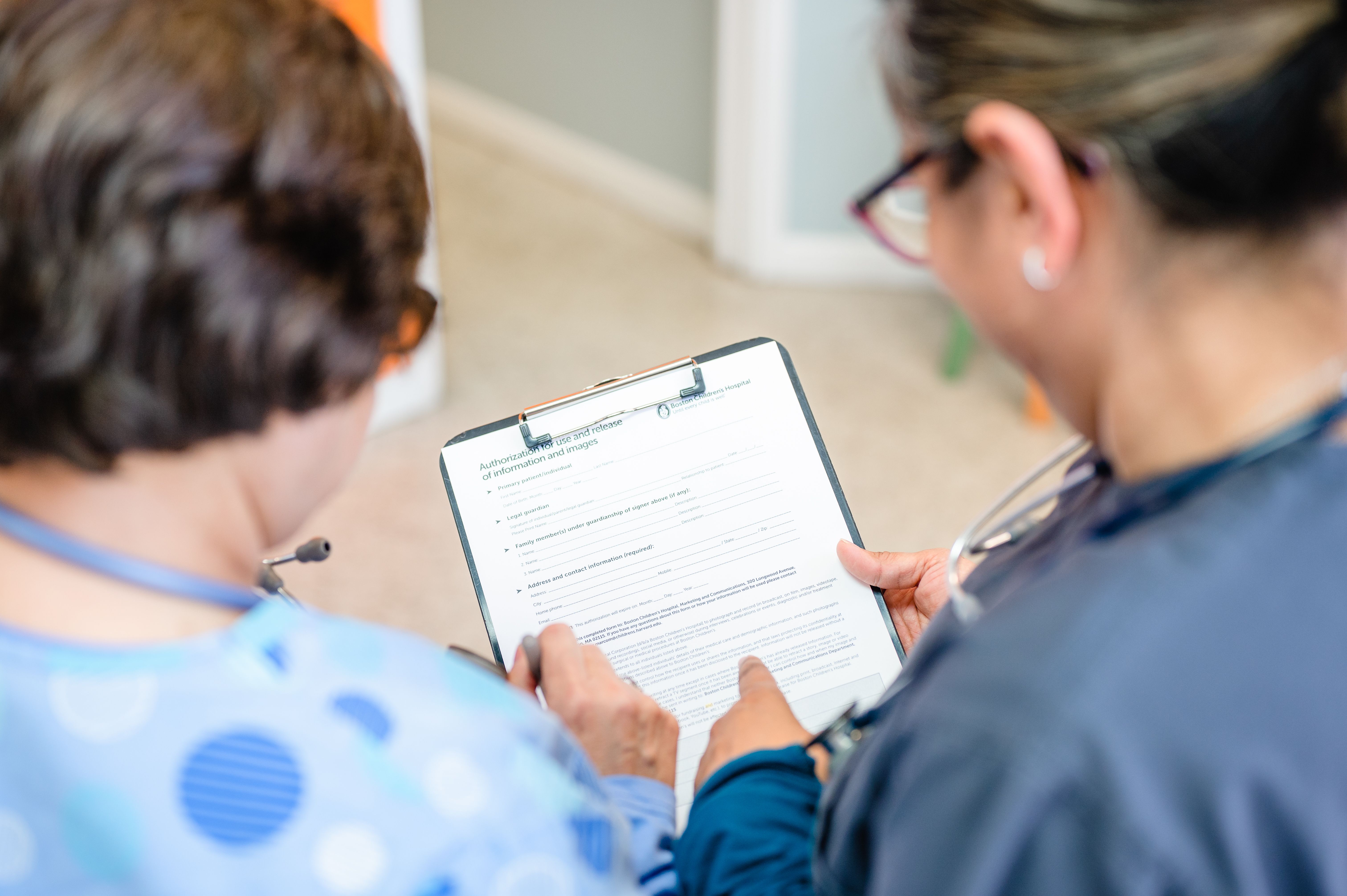 two women medical professionals looking at a clipboard